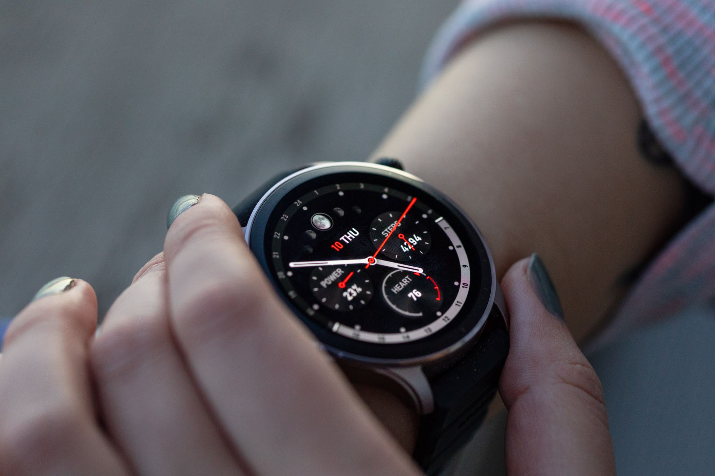 Amazfit GTR 4 on a woman's wrist with a closeup of an analog watch face