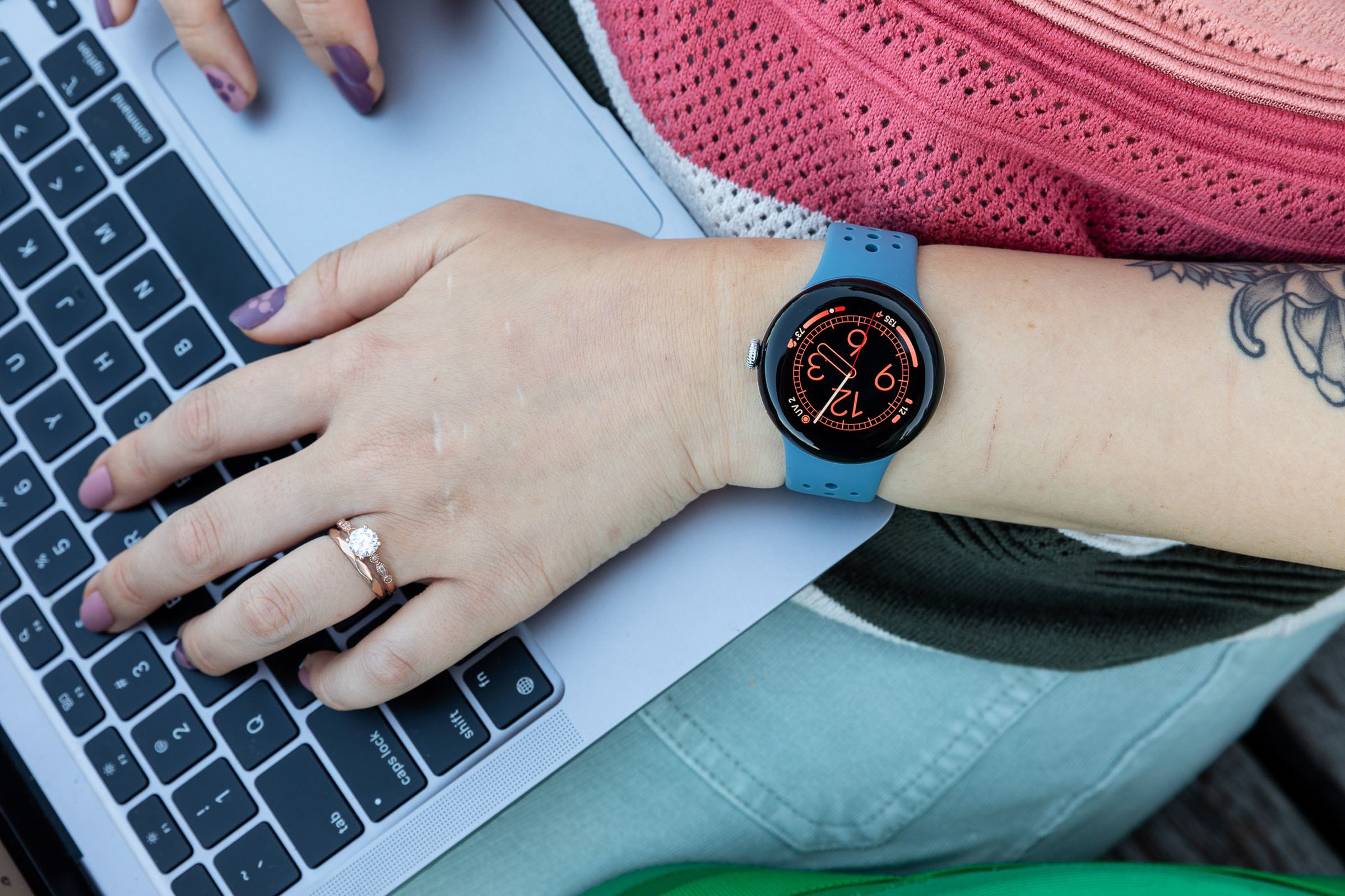 Person wearing Pixel Watch 2 while typing on a laptop