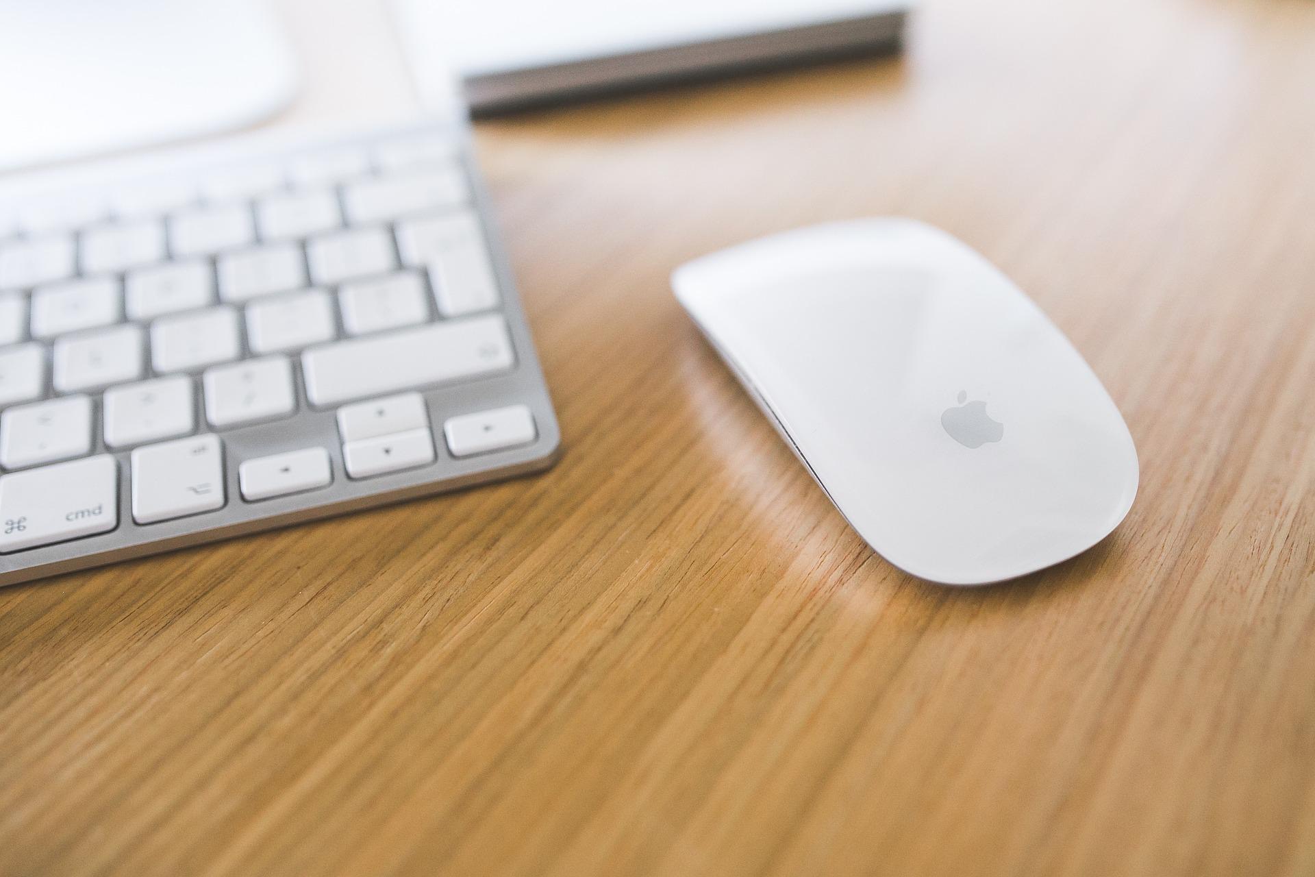 Magic Mouse next to a ⁢Mac⁣ keyboard on a desk.