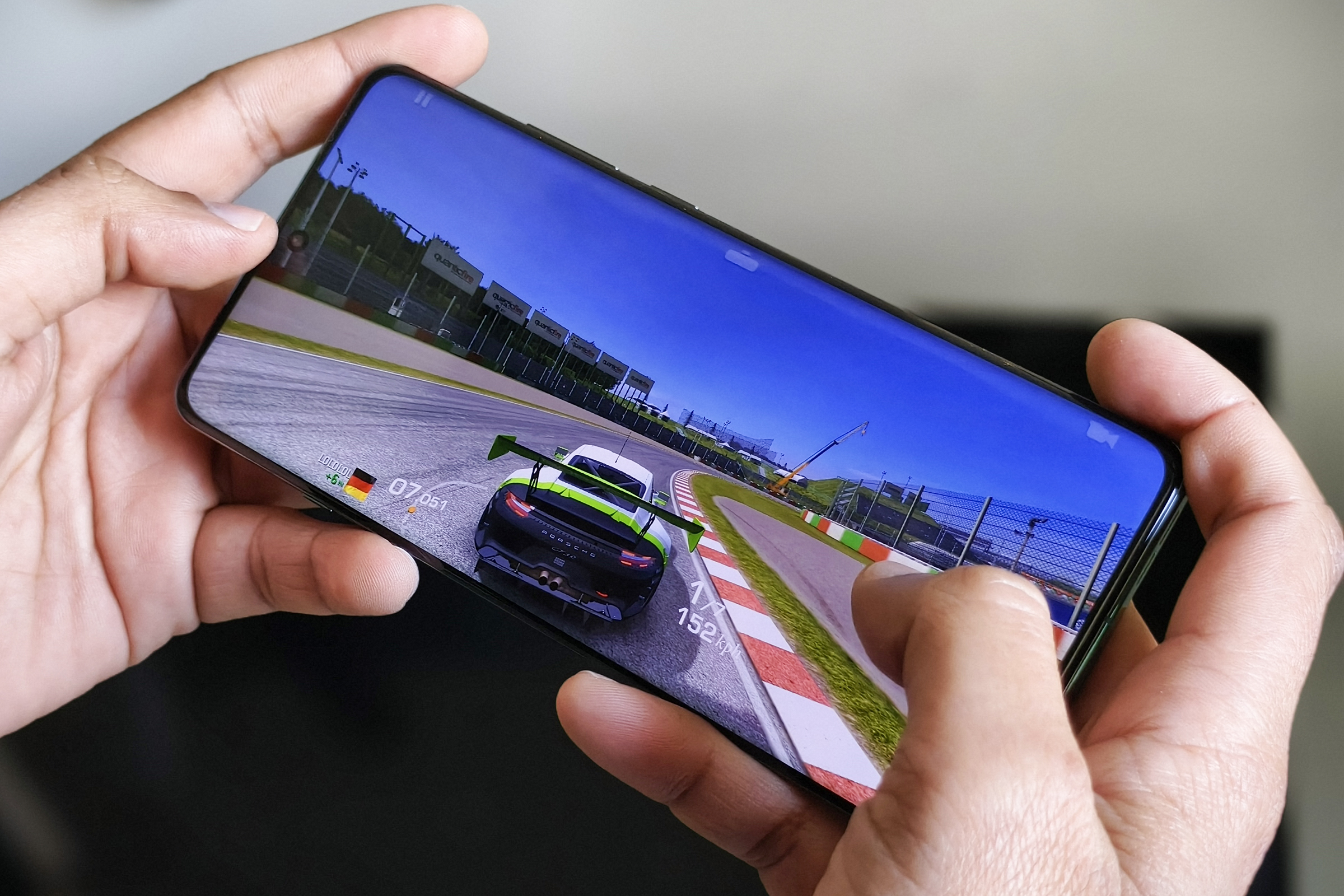 OnePlus 12 held in person's ‌hand running Real Racing 3.