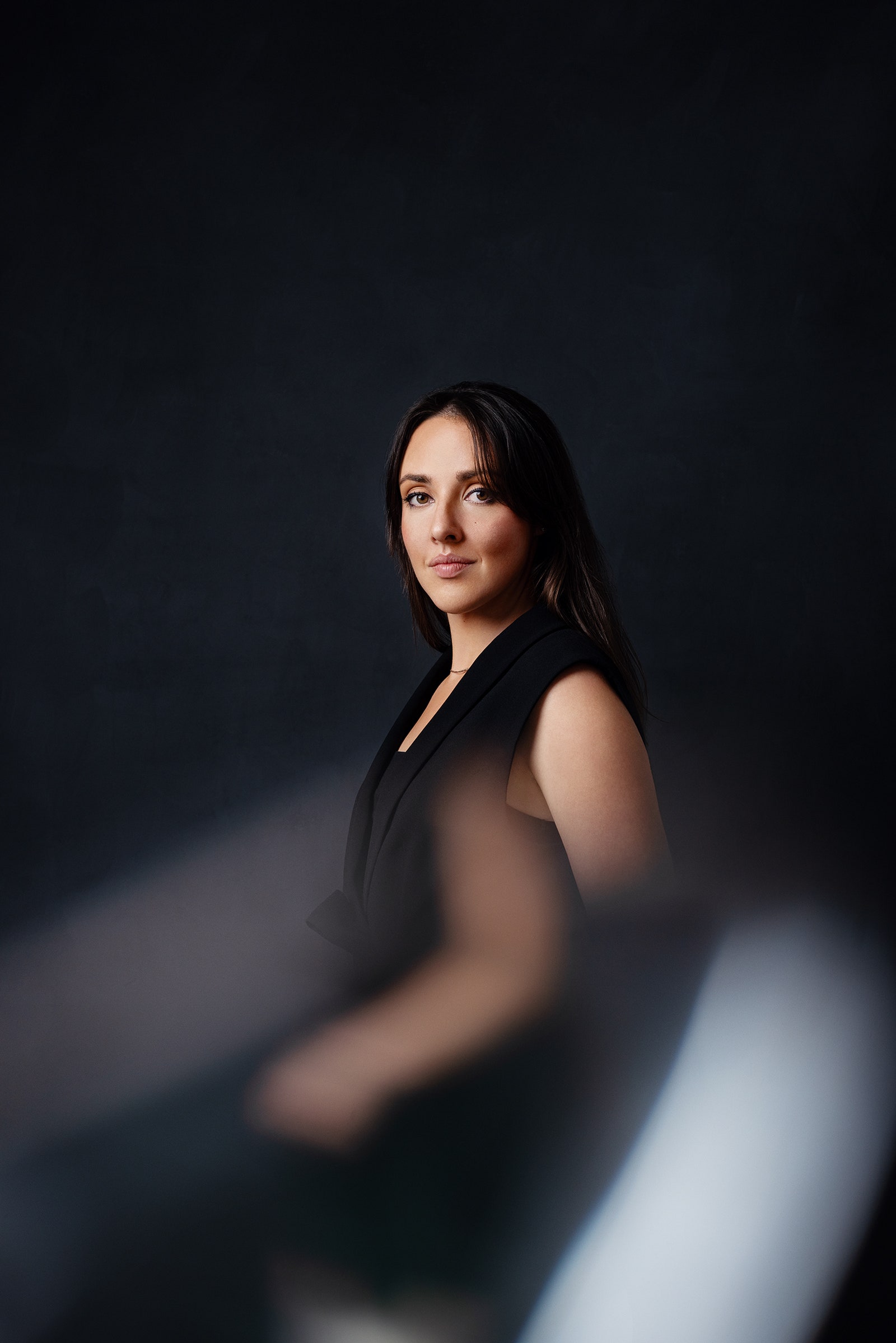 Person sitting in front of a black backdrop the bottom of the image is blurred and distorted