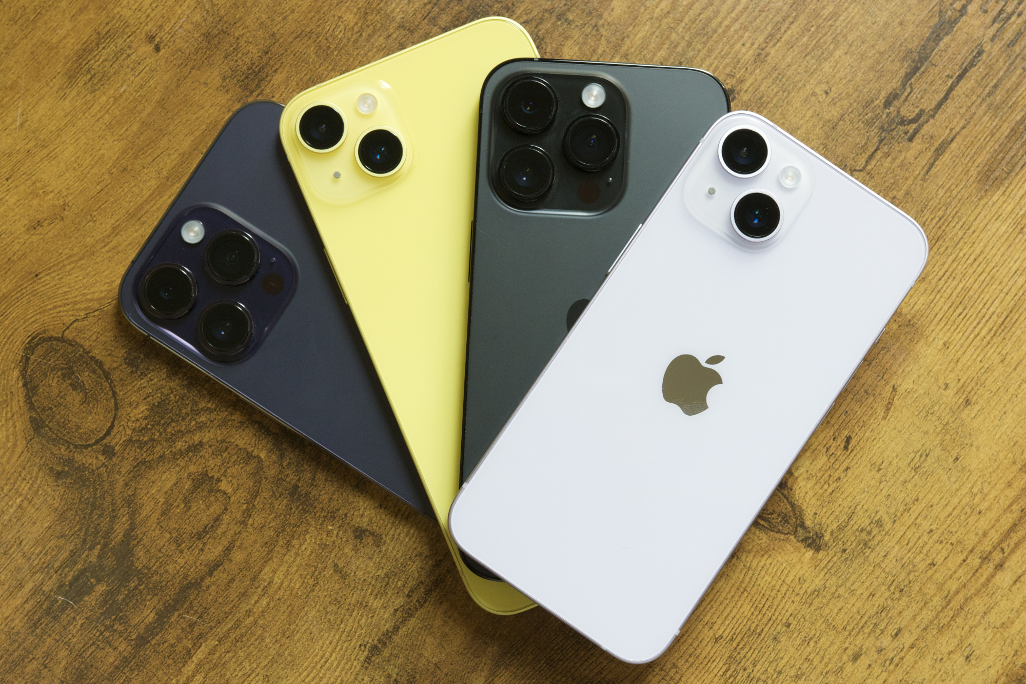 The iPhone‍ 14, iPhone​ 14 Plus, iPhone 14 Pro, and iPhone 14​ Pro Max all lying on a table.