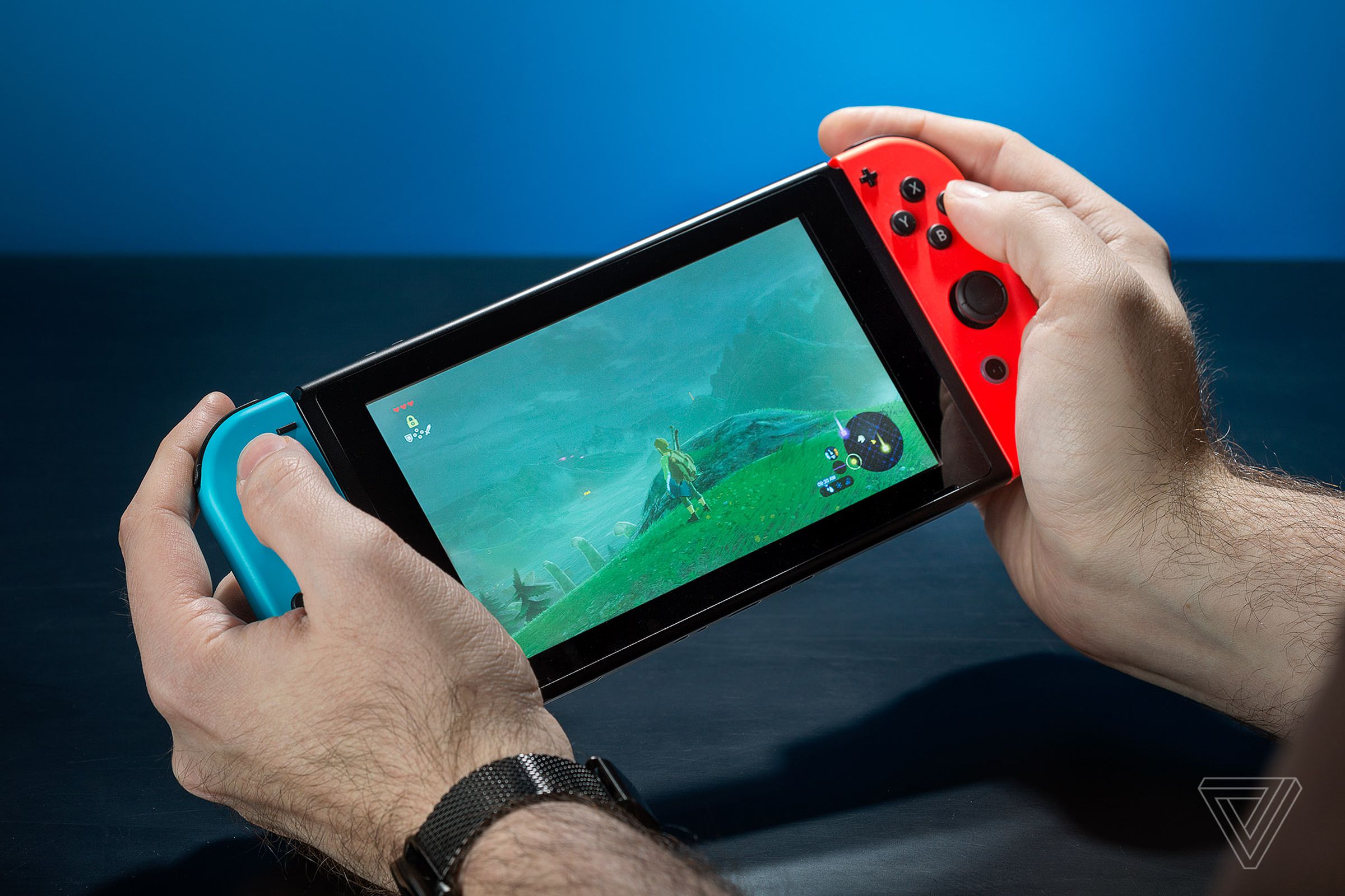 A person enjoying The Legend of Zelda: Breath of the Wild on a Nintendo Switch handheld device.