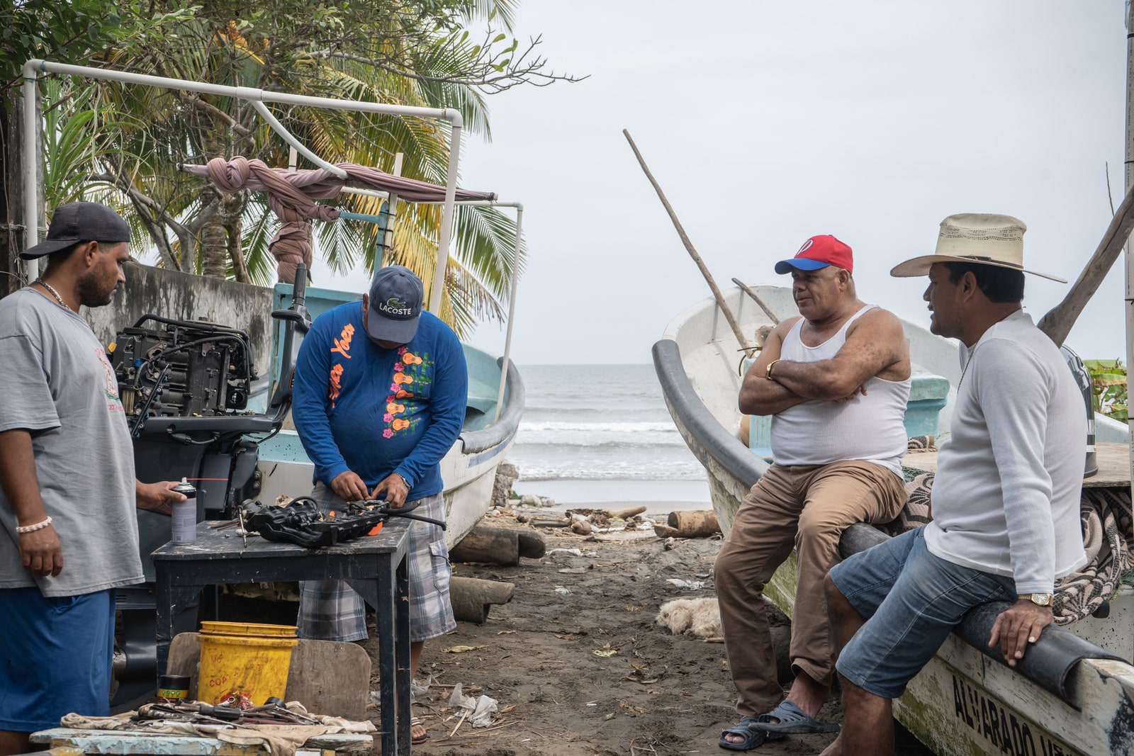 Fishermen fixing ⁣a⁣ motor ⁣in Barrancas, Mexico.