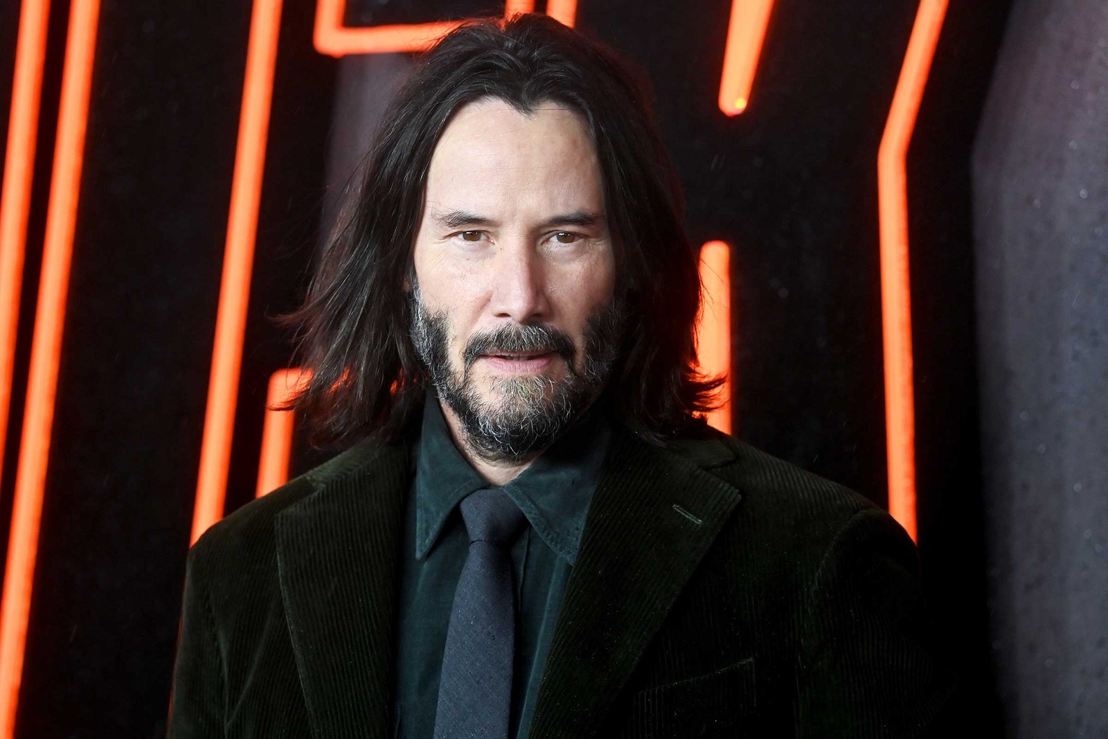 Keanu Reeves in front of a red neon sign